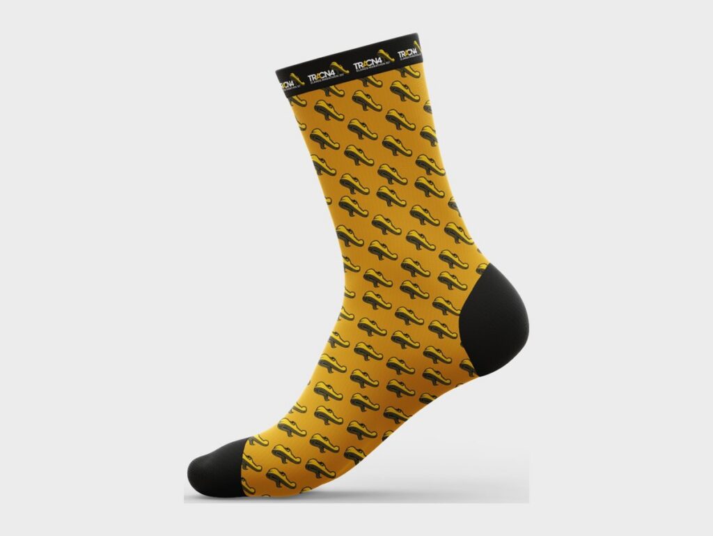 Yellow running sock with a pattern of race shoes, black heel and toe, and the race logo on the cuff